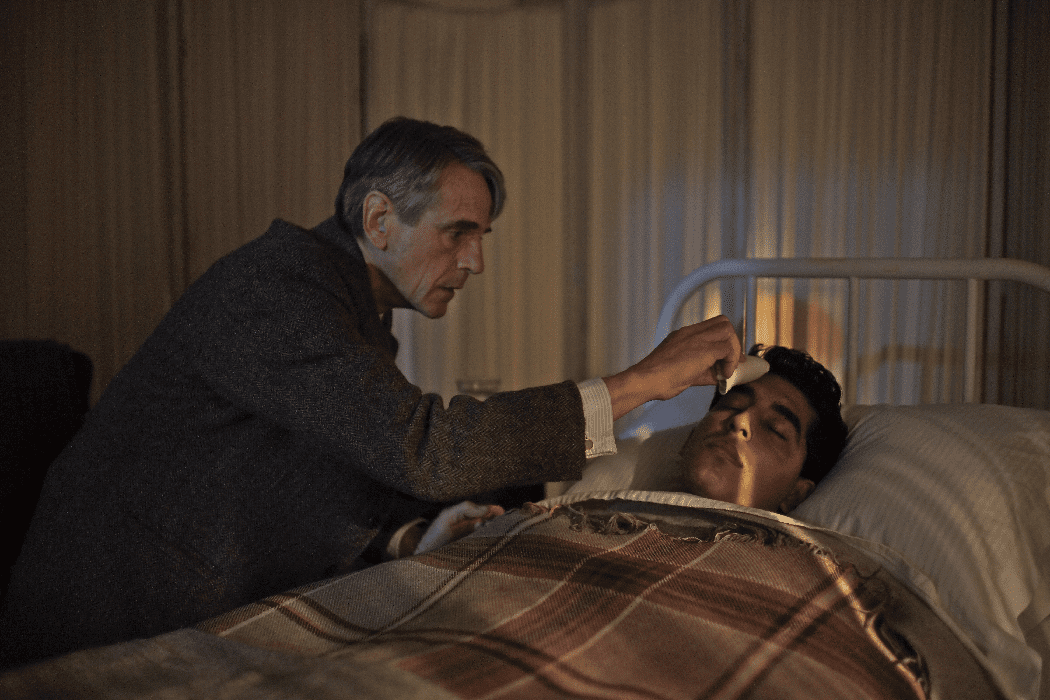 Hardy (Jeremy Irons) tends to Ramanujan (Dev Patel) in "The Man Who Knew Infinity." (Shaw Organisation)