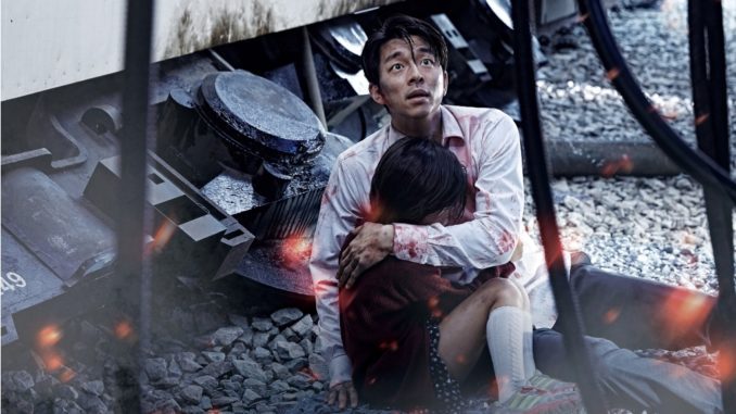 Seok-woo (Gong Yoo) cradles Su-an (Kim Su-an) in "Train to Busan." (Golden Village Pictures)