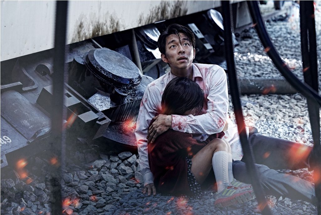 Seok-woo (Gong Yoo) cradles Su-an (Kim Su-an) in "Train to Busan." (Golden Village Pictures)
