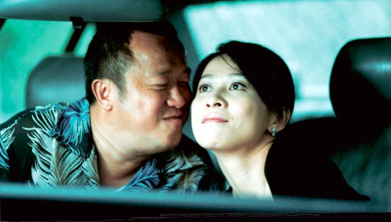 Hon Sam (Eric Tsang) and wife Mary (Carina Lau) in Infernal Affairs II. (Credit: Netflix and Media Asia Films)