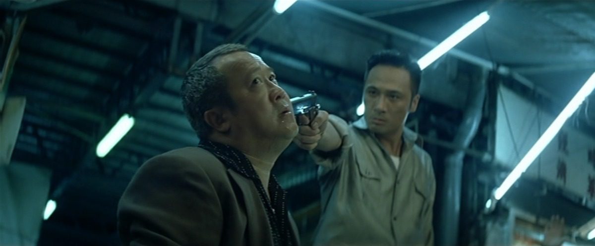 Ngai Wing-hau (Francis Ng) has Hon Sam (Eric Tsang) at gunpoint in Infernal Affairs II. (Credit: Netflix and Media Asia Films)