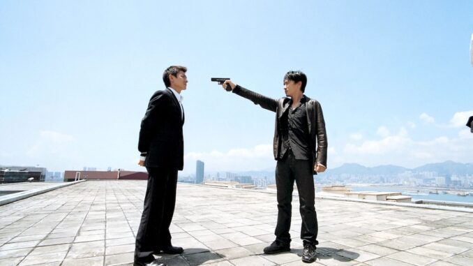 Chan Wing-yan (Tony Leung) has Lau Kin-ming (Andy Lau) at gunpoint in Infernal Affairs. (Credit: Netflix and Media Asia Films)